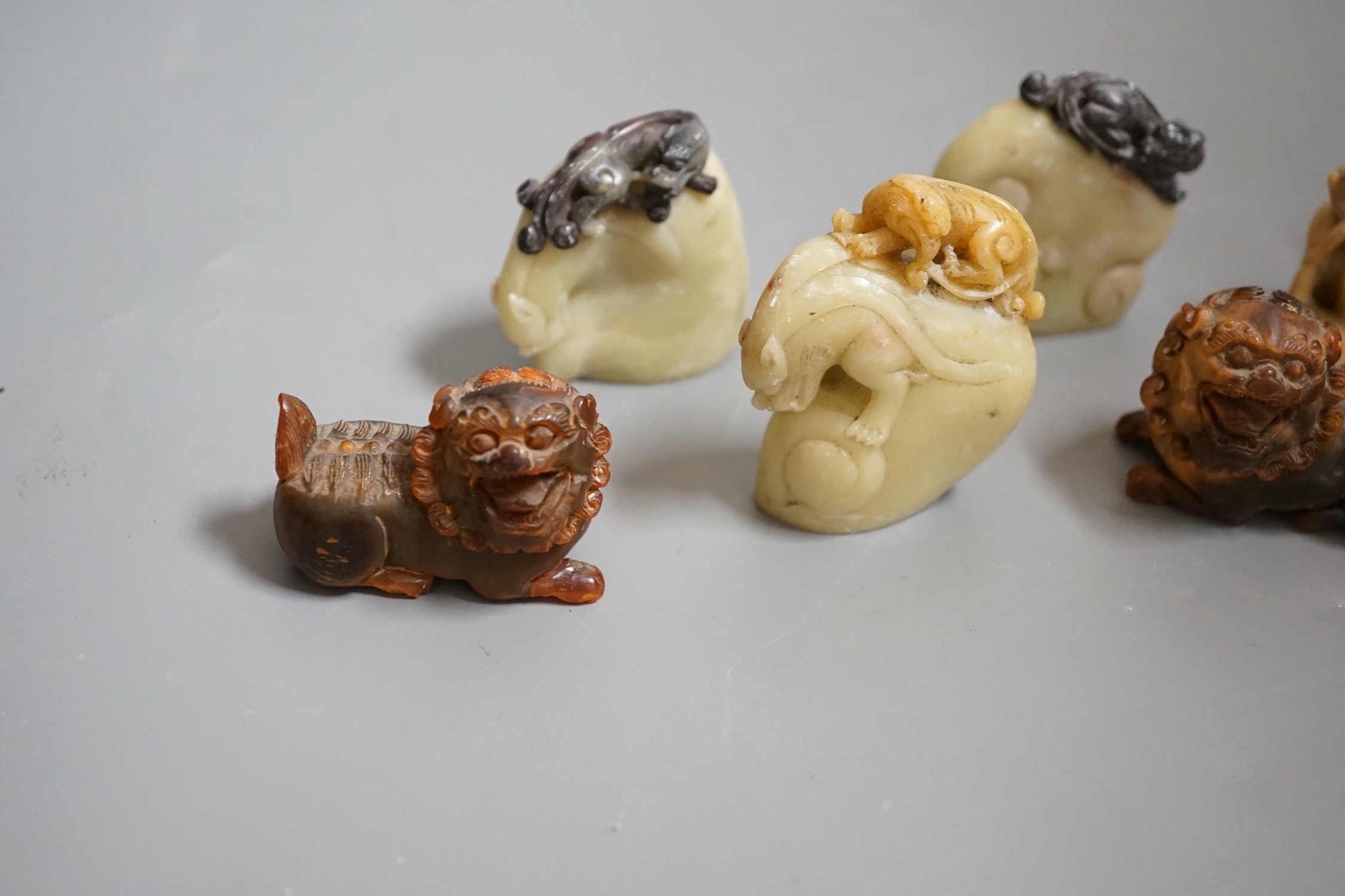 Two carved horn Buddhistic lions, four soapstone carvings and a pair of Chinese nickel and amber-glass ornaments, horn lions 5cm wide